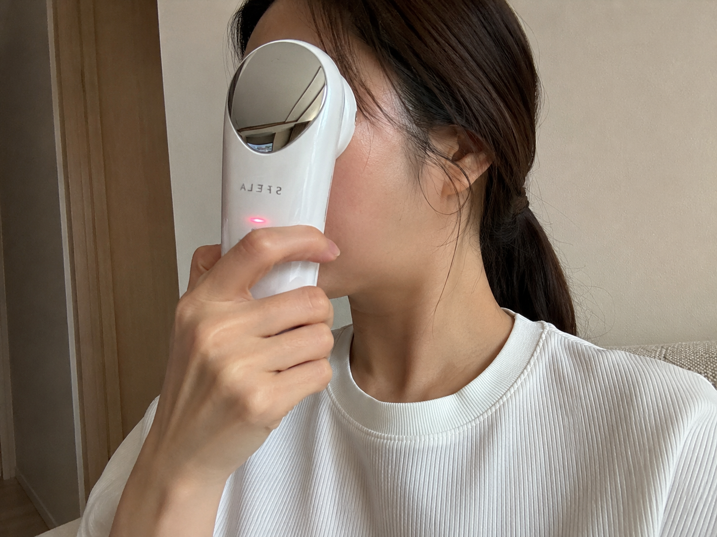 EMS美顔器を頬に当てて使用している様子