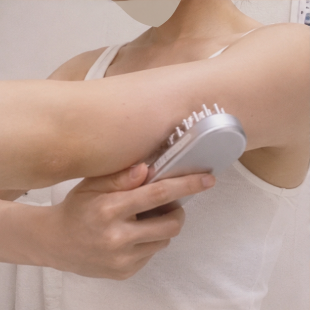 SALONIA EMSリフトブラシを二の腕に使用している様子